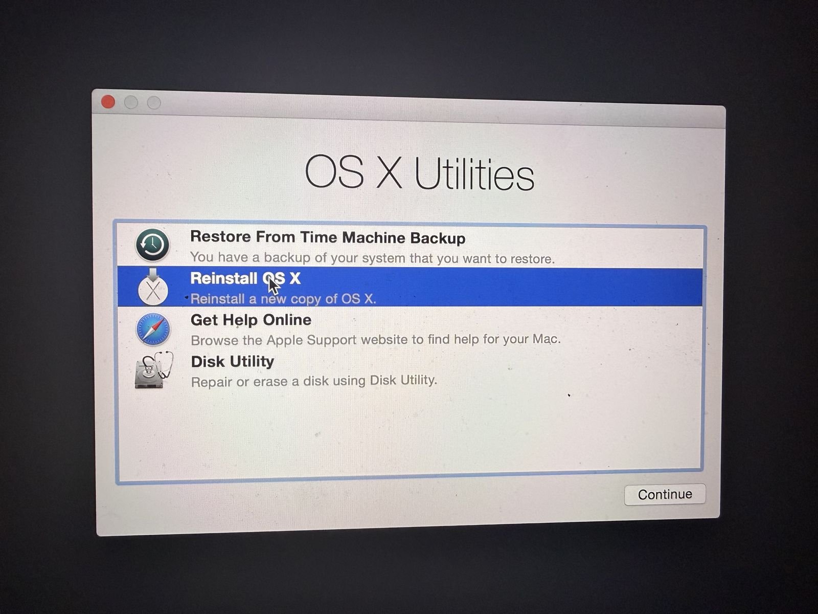 The macOS Utilities menu with Reinstall macOS selected